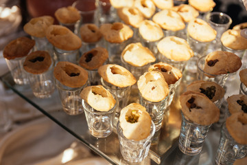 Panipuri consists of a round, hollow puri, fried crisp and filled with a mixture of flavored water, tamarind chutney, chili, chaat masala, potato, onion and chickpeas on the glass for Indian wedding.