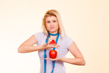 Woman choosing between apple and sweet cupcake