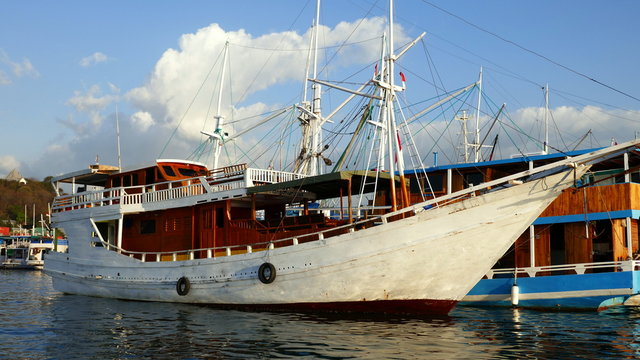 großes, weißes Holzschiff liegt im Hafen von Labuan Bajo auf der Insel Flores