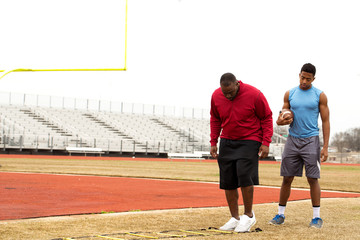 Coach training a high school athlete.