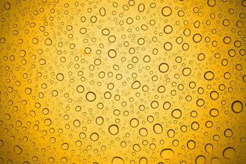 Water drops on yellow glass, Rain droplets on glass background.