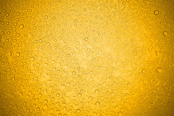 Water drops on yellow glass, Rain droplets on glass background.