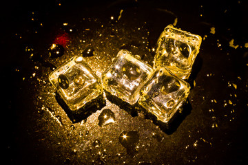 ice cubes and water drop on light golden background.