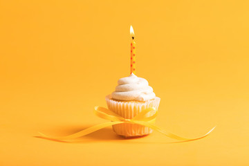 Cupcake with candle celebration theme on a yellow background