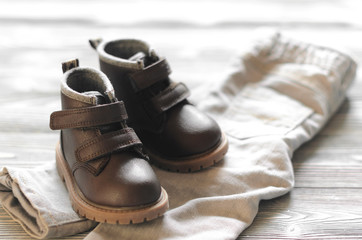 brown leather kids shoes and denim pants on wood backdrop