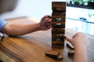Group of Friends playing blocks wood game on the table folded puzzle.