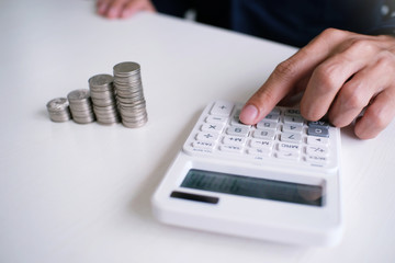 Accountant verify the business and saving money stacking gold coins with calculator. Accountancy Concept