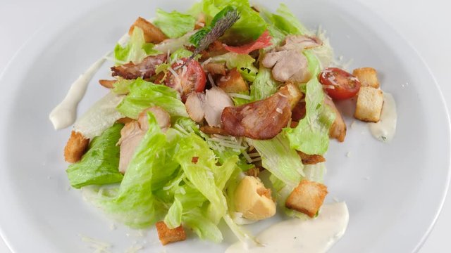 Caesar salad with chicken, served with parmesan cheese, bacon and croutons, loop, 4K, ProRes codec, 422 HQ