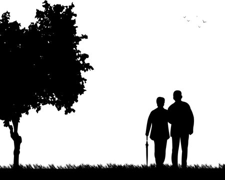 Lovely retired elderly couple walking with umbrella in park in autumn or fall, one in the series of similar images silhouette