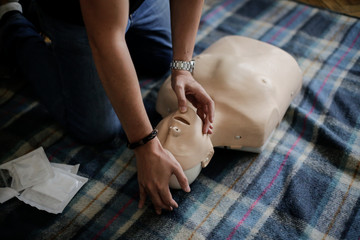 CPR training medical procedure - Demonstrating chest compressions on CPR doll - obrazy, fototapety, plakaty
