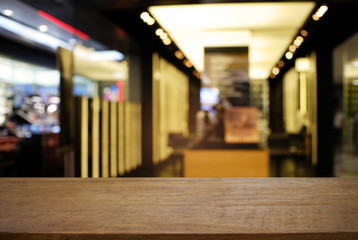 Empty dark wooden table in front of abstract blurred background of cafe and coffee shop interior. can be used for display or montage your products