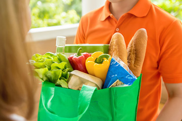 Grocery store delivey man  delivering food to a woman at home