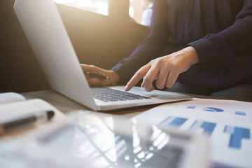 financial executive working on investment data with documents and laptop