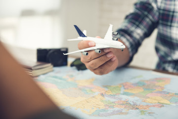 A man holding a plane model while planning holiday trip