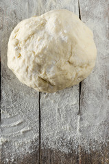 Kneaded dough on the table sprinkled with flour