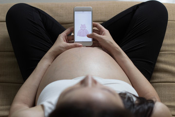 Pregnant woman shopping online on baby store.