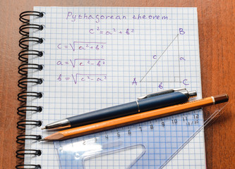 Page with formulas and the Pythagorean theorem with pen and pencil