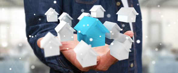 Businessman using 3D rendered small white and blue houses