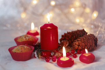 Close up of muffins in a red wrapper with red candles and holiday wreath. Bokeh background with a shallow depth of field