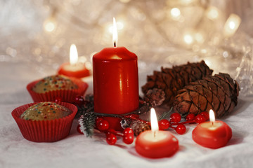 Close up of muffins in a red wrapper with red candles and holiday wreath. Bokeh background with a shallow depth of field