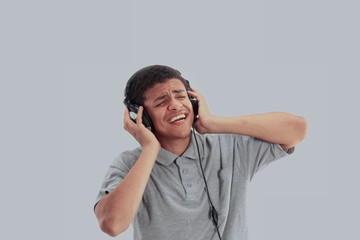 Young happy man listening to music and singing