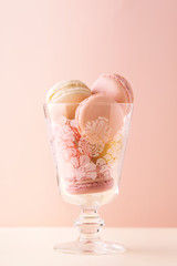 Macarons assortment in a transparent glass on a pastel background. French confectionery. Sweet food