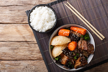 Korean stewed beef short ribs with vegetables and rice garnish close-up. Horizontal top view