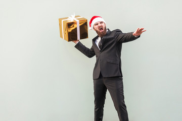 Catch your gift! Young adult well dressed bearded man swung and wants to throw off your gift box, isolated on gray background.