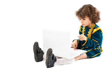 Personal computer and a boy dressed as a king