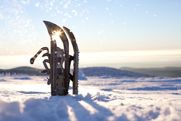 Schneeschuhe stecken im Tiefschnee im Harz und glitzern im Sonnenschein