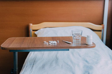 pills and thermometer on table
