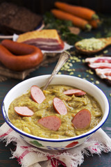 Traditional Dutch pea soup and ingredients on a rustic table