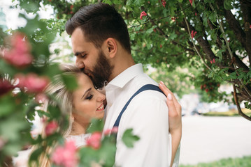 Young, beautiful bride and groom walking along in the park