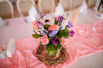 Beautiful table decoration made of vase with colorful flowers