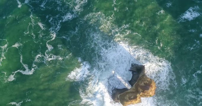 One limestone eroded disconnected standing rock &ndash; apostle at twelve apostles marine park in top down aerial view.
