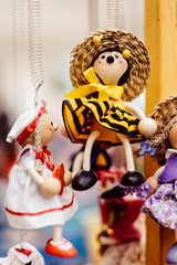 Wooden dolls dressed in diffirent outfits. handmade wooden dolls hanging as a display. decirative dolls