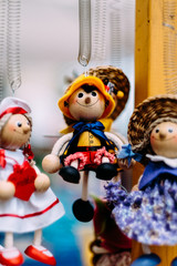 Wooden dolls dressed in different outfits. handmade wooden dolls hanging as a display. decorative dolls