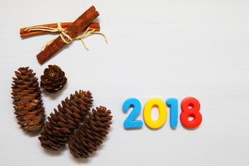 Colorful figures 2018 and cones on white background. Festive Christmas winter concept.
