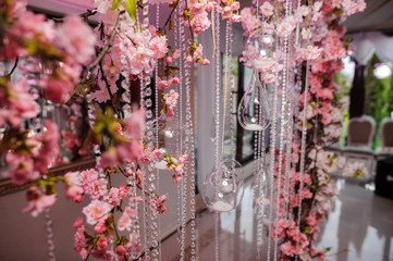 Wedding arch decorated with beautiful pink flowers and beads