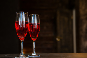 Two glass glasses, a decanter with pink champagne, wine, stand on a blurred background of a brick wall. Romantic evening, date. Place for the inscription. Titles