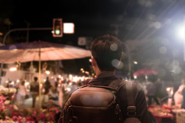 Obraz premium Male tourist sightseeing flea market,traveling concept.Street photographer wandering on famous night walking street in chiengmai city, northern Thailand.