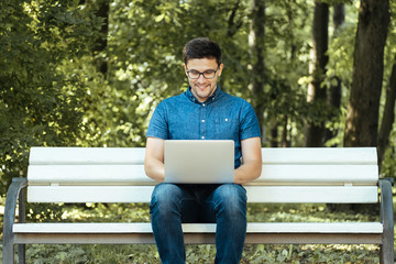 Fototapeta premium Man using laptop in city park