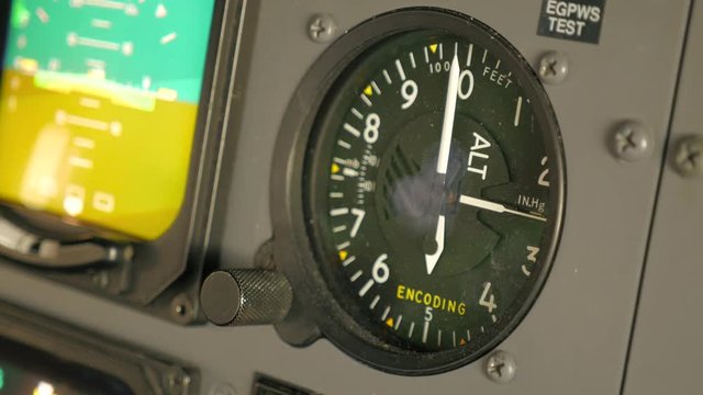 Pilot adjusts dusty altimeter on old aircraft and taps it with finger