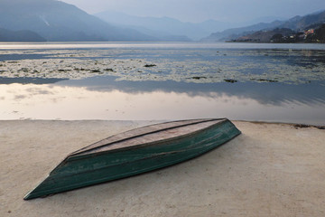 An inverted boat on a concrete embankment