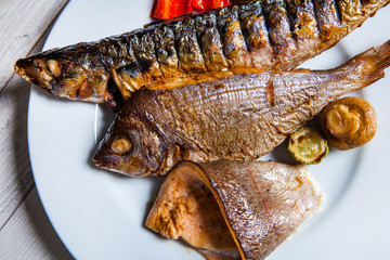 Assortment of fried fasting fish, Mackerel, trout, carp. Top view on grilled seafood variety. Mediterranean cuisine, healthy food, restaurant menu, buffet concept. Grilles fish in plate