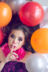 Cute clown holding her hand next to the face. Party
