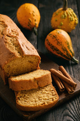 Homemade pumpkin cake on black wooden background.