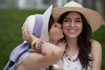 Girl kissing another girl in the cheek