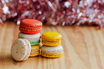 Close up macaron on bokeh background. Homemade delicious macaron stack on wood table with copy space for background or wallpaper macro concept. Macarons is French dessert served with tea or coffee.