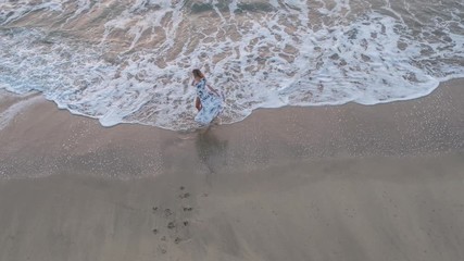 4k Aerial Drone View of Young Woman In Fashion Dress Circling Around on The Sandy Beach